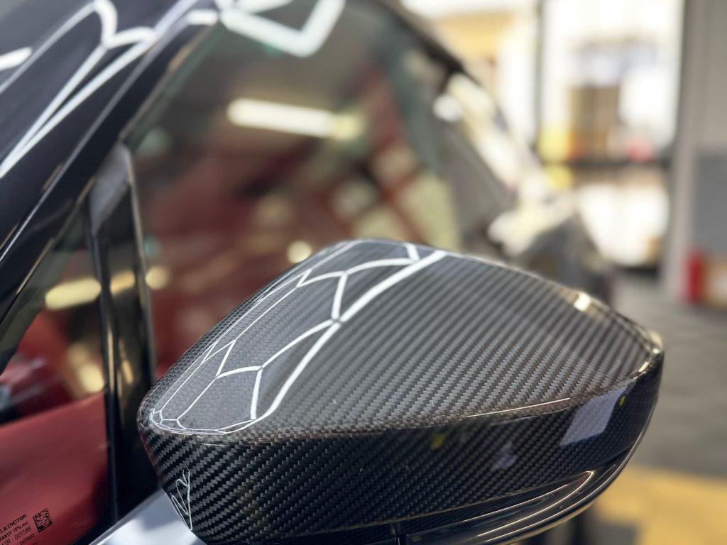 Nahaufnahme einer in Carbonoptik folierten Spiegelkappe – Detailfolierung von CK Folientechnik München