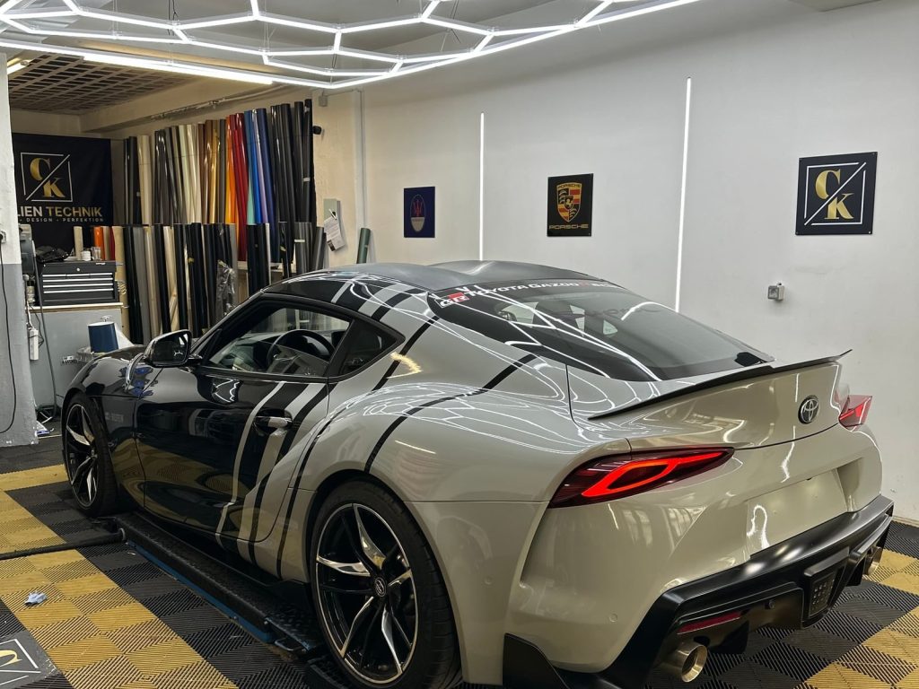 Heller Sportwagen mit schwarz abgesetzten Zierelementen in der Werkstatt – Detailfolierung von CK Folientechnik München